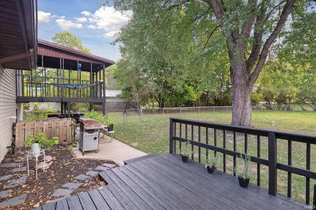 wooden deck with area for grilling and a lawn