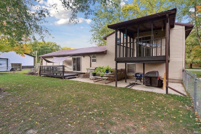 back of property featuring a yard, a patio, a balcony, and a wooden deck