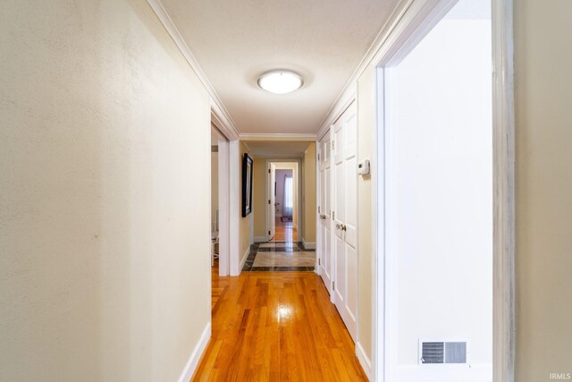 hallway featuring wood-type flooring and ornamental molding