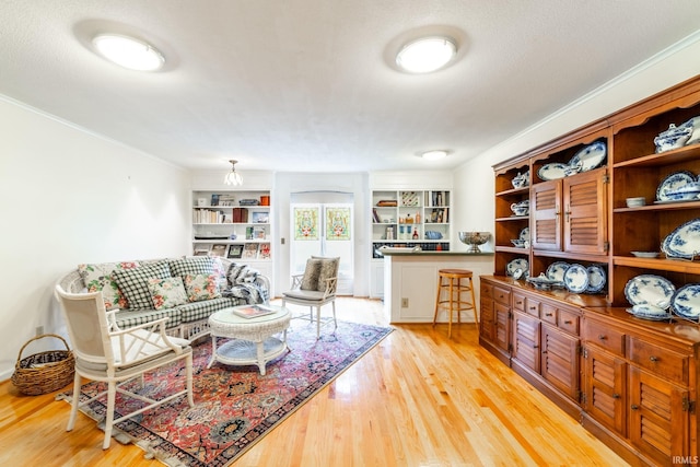 living room featuring ornamental molding, a textured ceiling, and light hardwood / wood-style floors