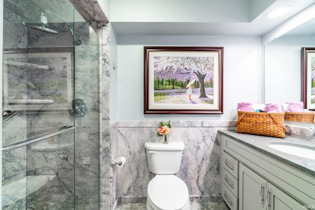 bathroom with toilet, an enclosed shower, vanity, and tile walls