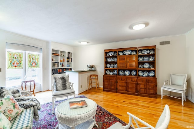 living room featuring light hardwood / wood-style flooring and ornamental molding