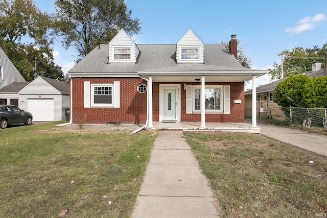 view of front facade featuring a front yard, a porch, an outbuilding, and a garage