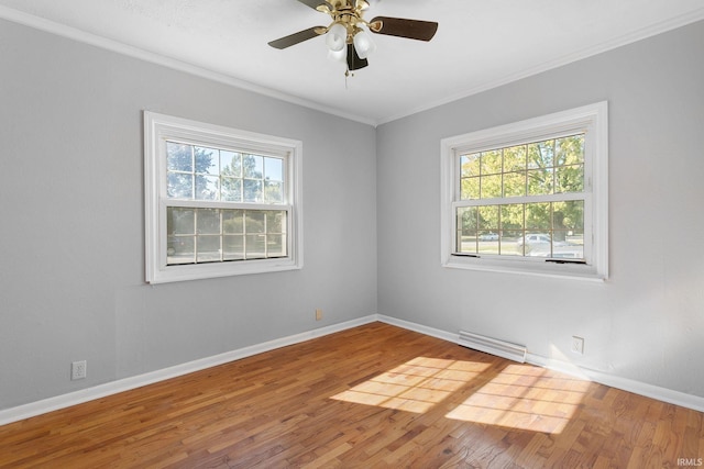 spare room with ornamental molding, hardwood / wood-style flooring, and a wealth of natural light