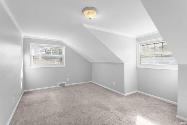 bonus room featuring vaulted ceiling, plenty of natural light, and light colored carpet