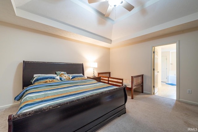 carpeted bedroom featuring a raised ceiling and ceiling fan