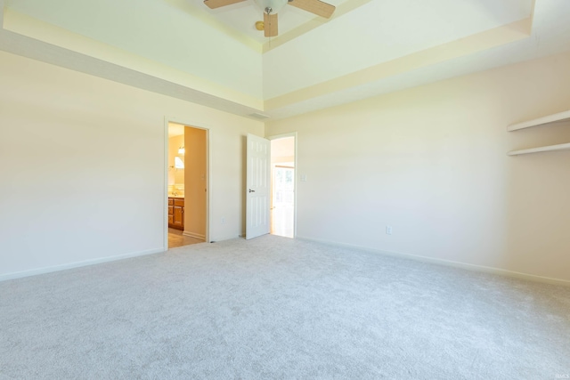 unfurnished room featuring baseboards, a high ceiling, light carpet, and a ceiling fan