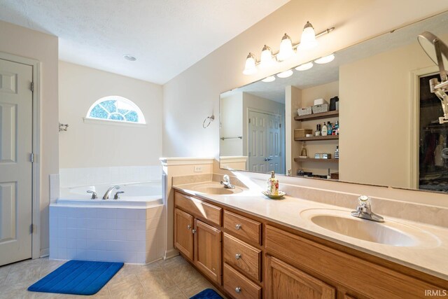 bathroom featuring vanity, tile patterned flooring, and tiled tub