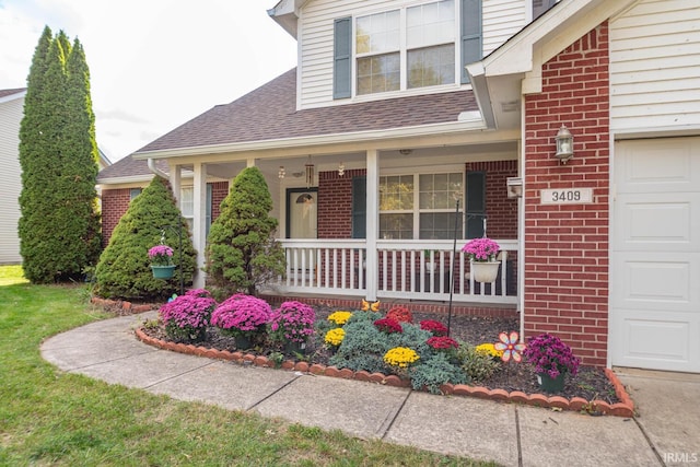 entrance to property with a porch, an attached garage, roof with shingles, and brick siding