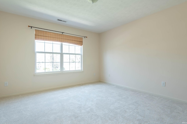unfurnished room with baseboards, carpet flooring, and visible vents