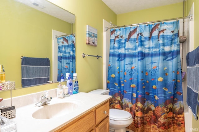 bathroom featuring vanity, a textured ceiling, toilet, and walk in shower