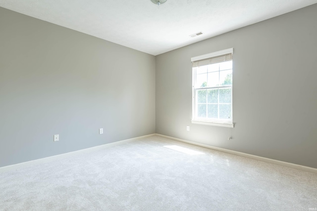 carpeted empty room featuring baseboards and visible vents