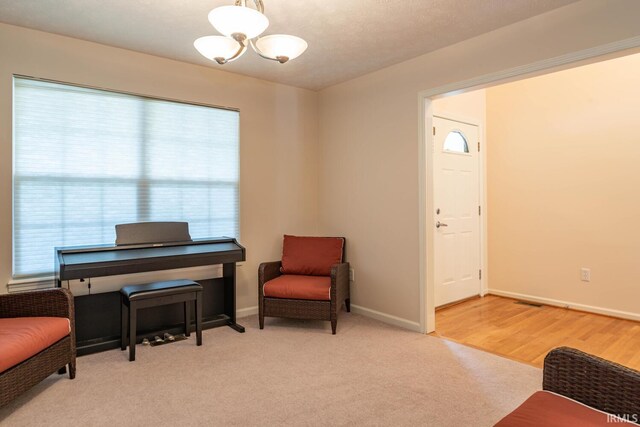 sitting room with light hardwood / wood-style floors and an inviting chandelier