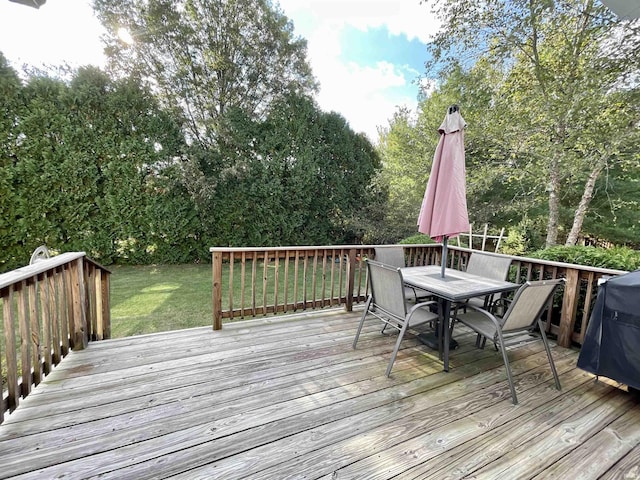 deck with outdoor dining area and a lawn