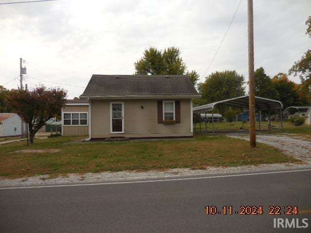 view of front of property with a front lawn and a carport