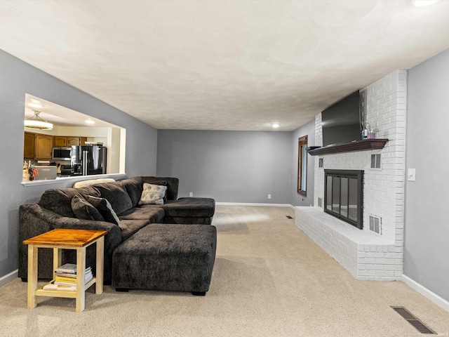 living room featuring light carpet and a brick fireplace