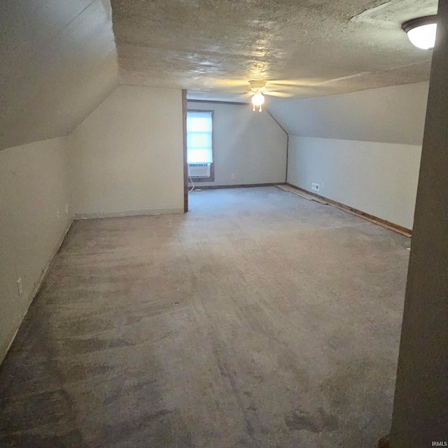 additional living space featuring lofted ceiling and a textured ceiling