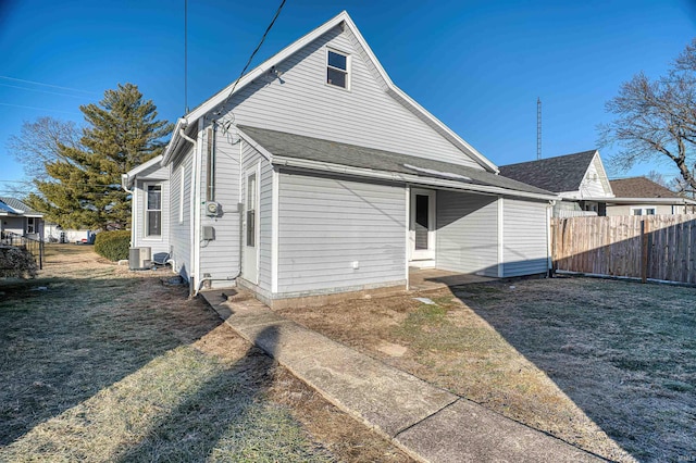 back of property featuring a yard and central AC