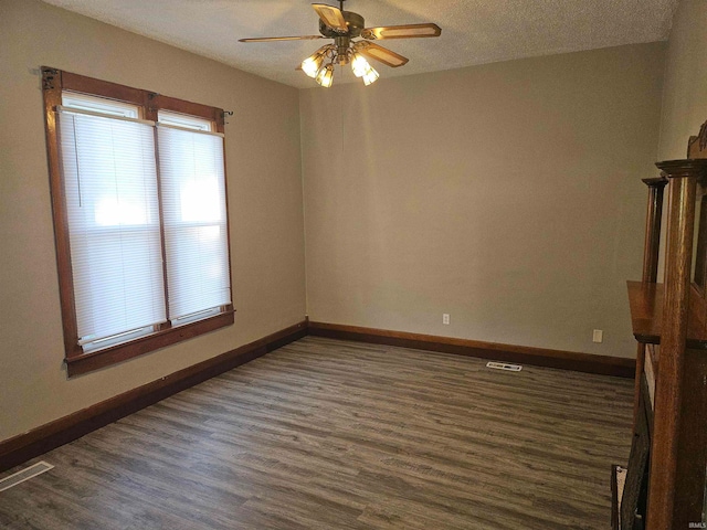 spare room featuring dark wood-type flooring and ceiling fan