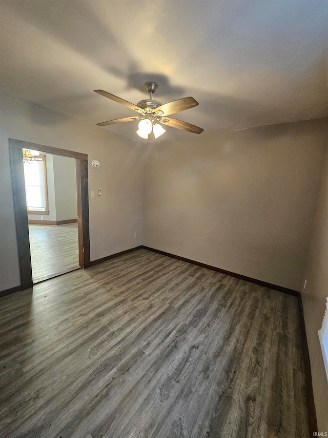 empty room featuring dark wood-type flooring and ceiling fan