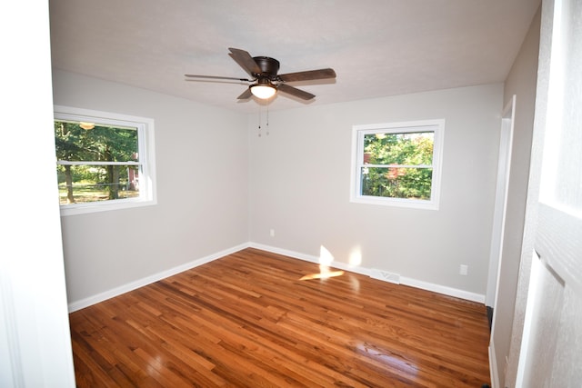 spare room featuring hardwood / wood-style floors, a healthy amount of sunlight, and ceiling fan