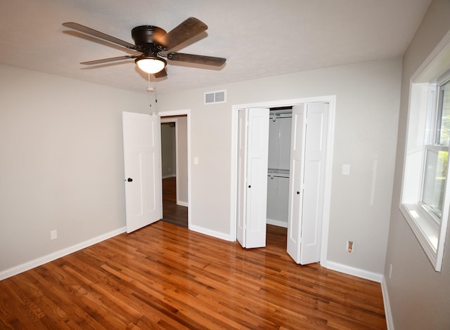 unfurnished bedroom featuring a closet, hardwood / wood-style floors, and ceiling fan