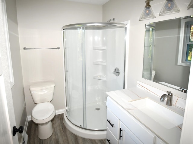 bathroom featuring toilet, an enclosed shower, hardwood / wood-style flooring, and vanity