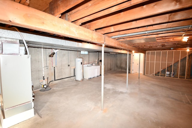 basement featuring water heater and washer / clothes dryer