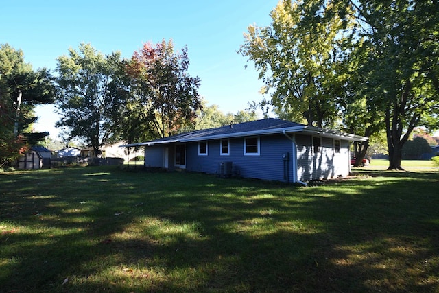 exterior space with a yard, a storage shed, and central AC unit