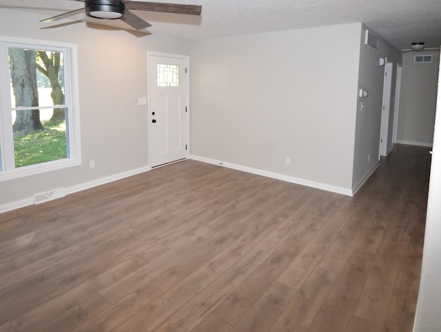 interior space with dark wood-type flooring, ceiling fan, and a textured ceiling