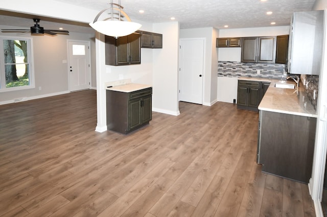 kitchen with a textured ceiling, dark hardwood / wood-style floors, sink, and pendant lighting