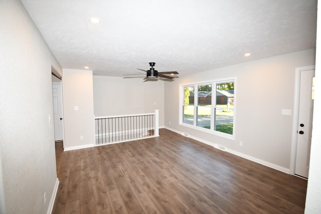 spare room featuring a textured ceiling, ceiling fan, and dark hardwood / wood-style flooring