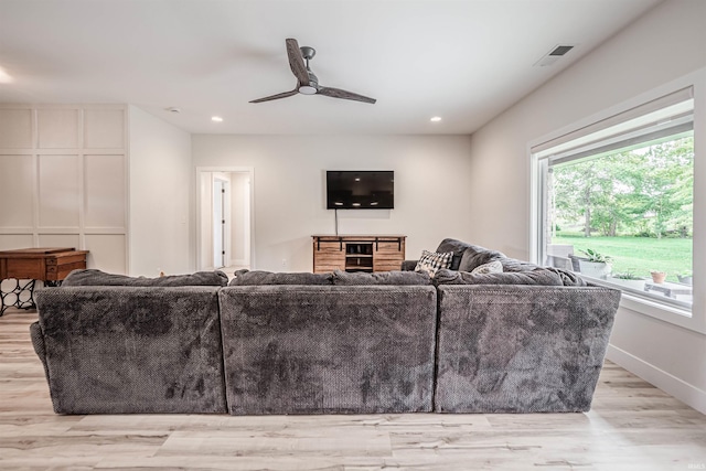 living room with light hardwood / wood-style floors and ceiling fan