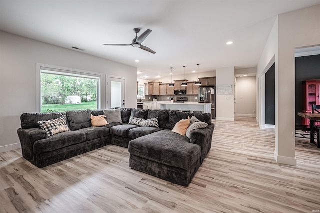 living room featuring light wood-type flooring and ceiling fan