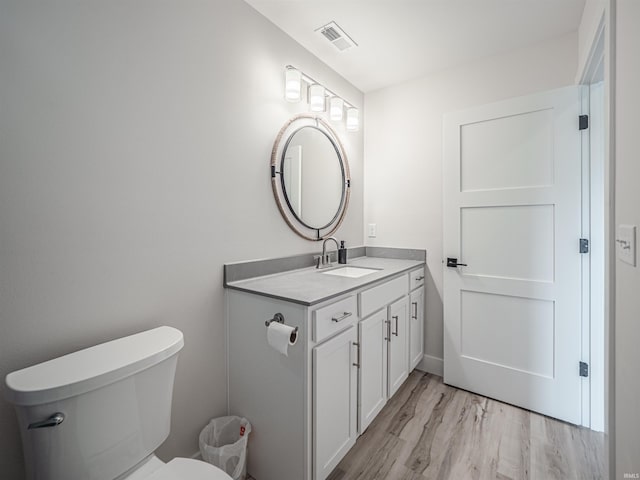 bathroom featuring vanity, toilet, and hardwood / wood-style floors