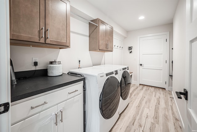 washroom with light wood-type flooring, separate washer and dryer, and cabinets