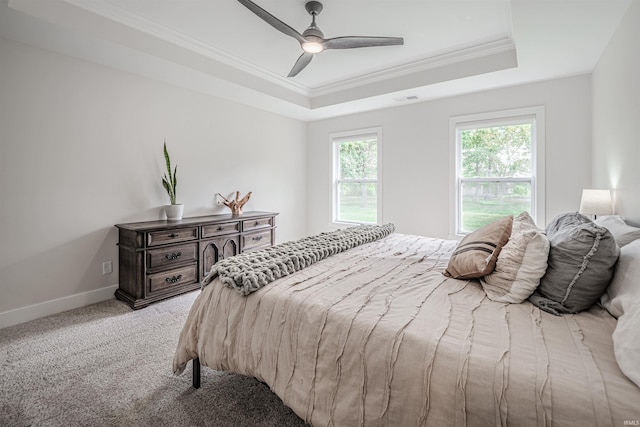 carpeted bedroom featuring crown molding, a tray ceiling, and ceiling fan