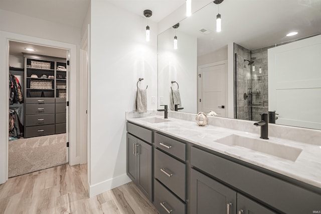 bathroom with vanity, a shower with shower door, and hardwood / wood-style floors