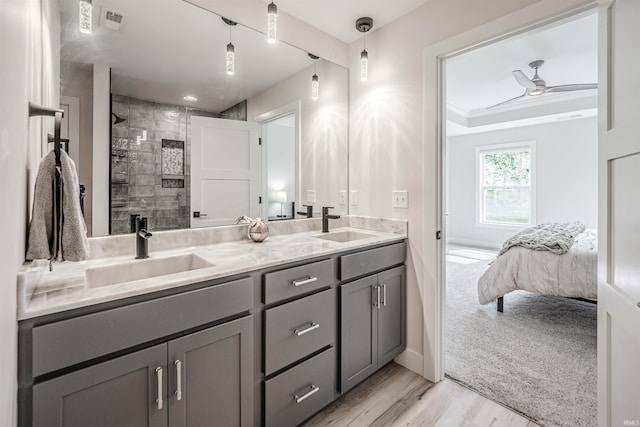 bathroom featuring hardwood / wood-style floors, ceiling fan, walk in shower, vanity, and crown molding