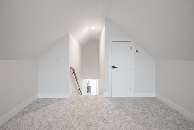 additional living space featuring vaulted ceiling and carpet floors