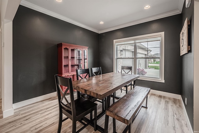 dining area featuring ornamental molding and light hardwood / wood-style flooring