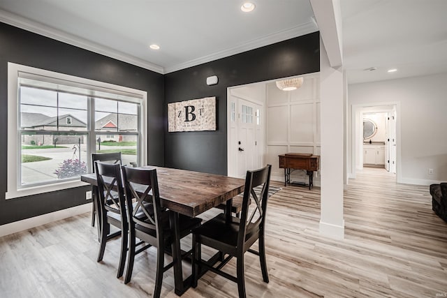 dining room featuring ornamental molding and light wood-type flooring