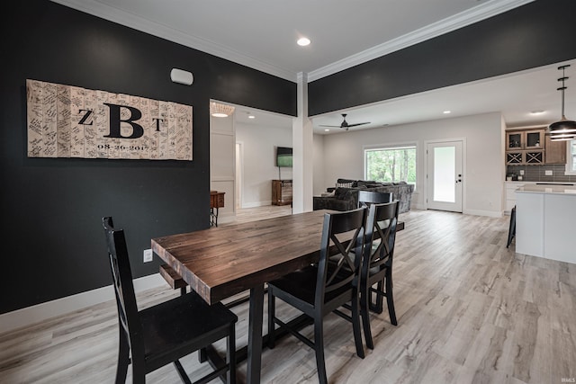 dining room with ornamental molding, light hardwood / wood-style flooring, and ceiling fan