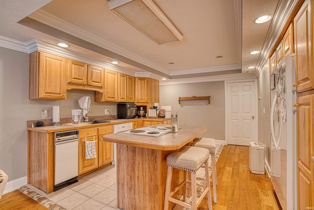 kitchen with light hardwood / wood-style flooring, ornamental molding, a breakfast bar, a raised ceiling, and white appliances