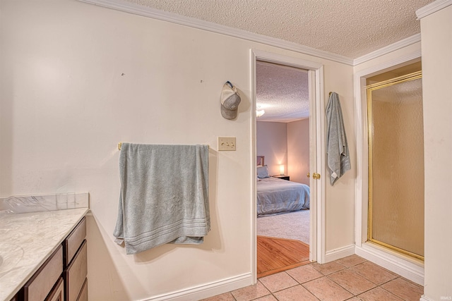 bathroom featuring a textured ceiling, a shower with shower door, vanity, crown molding, and tile patterned flooring