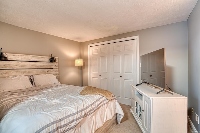 bedroom featuring a closet, a textured ceiling, and light colored carpet