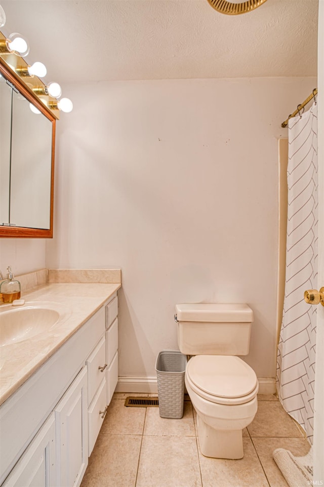 bathroom with a textured ceiling, toilet, vanity, tile patterned floors, and a shower with shower curtain