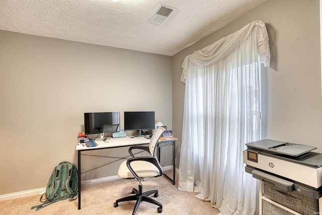 carpeted office space featuring a textured ceiling