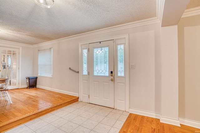 foyer entrance featuring light hardwood / wood-style flooring, a textured ceiling, and crown molding