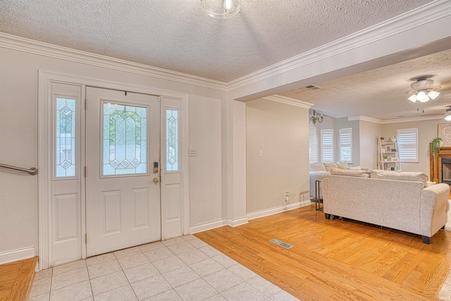 foyer featuring crown molding, a healthy amount of sunlight, light wood-type flooring, and ceiling fan